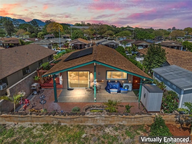 exterior space with a patio, solar panels, and a shed