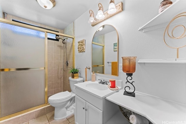 bathroom with tile patterned floors, toilet, vanity, and a shower with shower door