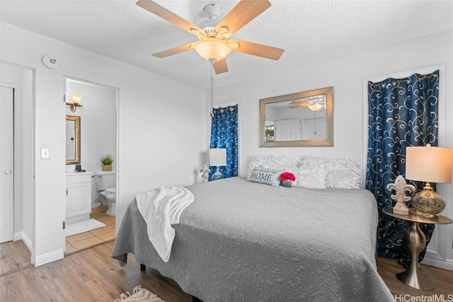 bedroom featuring a textured ceiling, ensuite bathroom, ceiling fan, and light hardwood / wood-style flooring