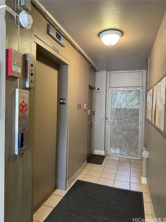 entryway with light tile patterned floors and elevator