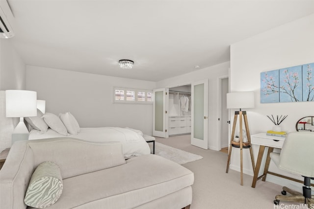 bedroom featuring light carpet, a wall unit AC, and baseboards