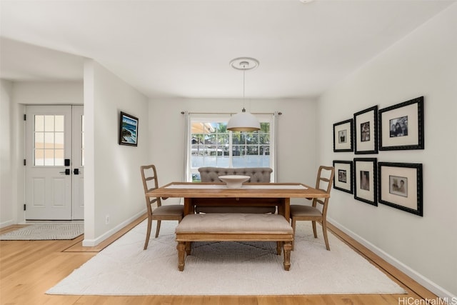 dining space featuring light wood-style flooring and baseboards