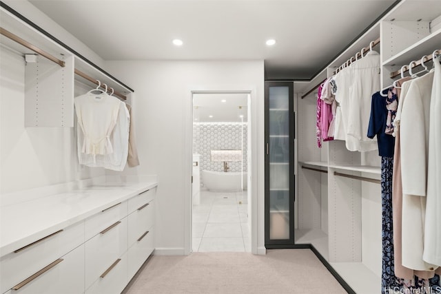 spacious closet with light tile patterned floors and light colored carpet