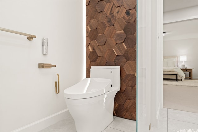 bathroom with toilet, baseboards, connected bathroom, and tile patterned floors