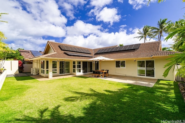 rear view of property featuring a patio area, a tile roof, a lawn, and a fenced backyard