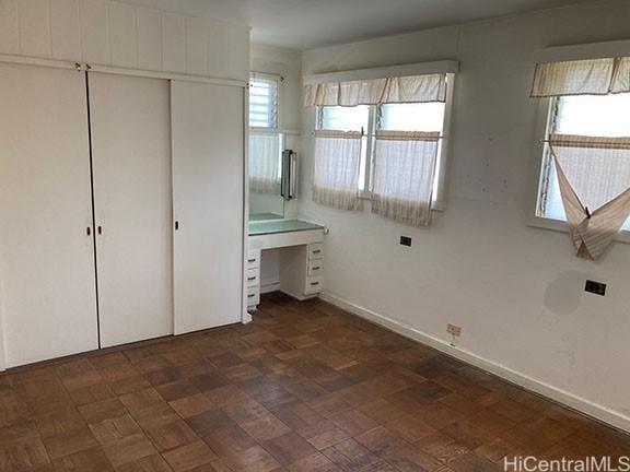 unfurnished bedroom featuring a closet and baseboards