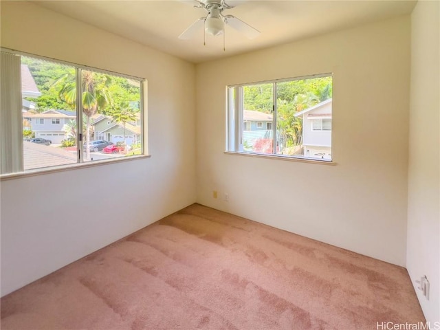 carpeted spare room featuring a ceiling fan