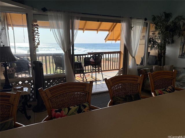 dining room with a water view, tile patterned floors, and a healthy amount of sunlight