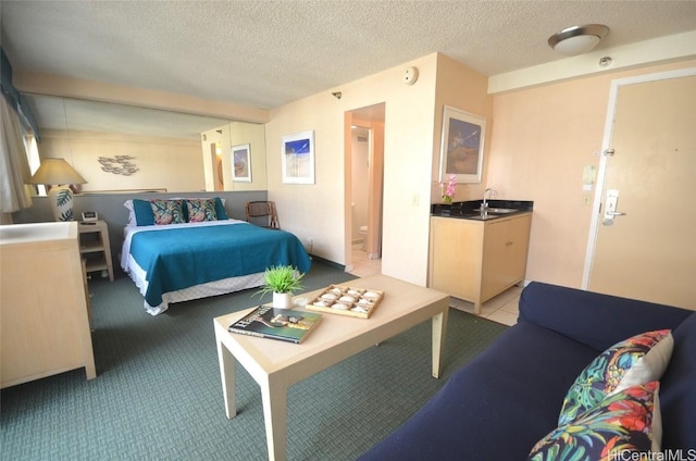 bedroom with a textured ceiling, a sink, and light colored carpet