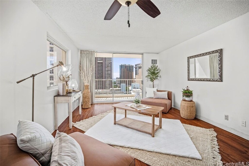 400 Hobron Ln Unit 2015, Honolulu, HI 96815 - living room with a textured ceiling, ceiling fan, hardwood / wood-style flooring, and a wall of windows