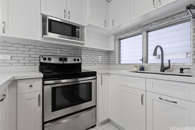 kitchen featuring white cabinetry, stainless steel appliances, tasteful backsplash, and sink