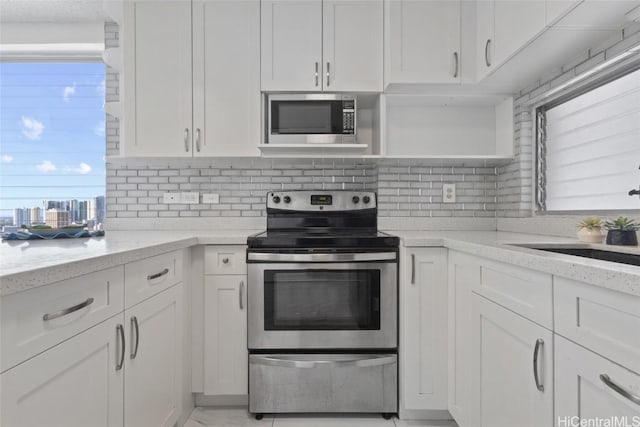 kitchen featuring a wealth of natural light, stainless steel appliances, and white cabinets