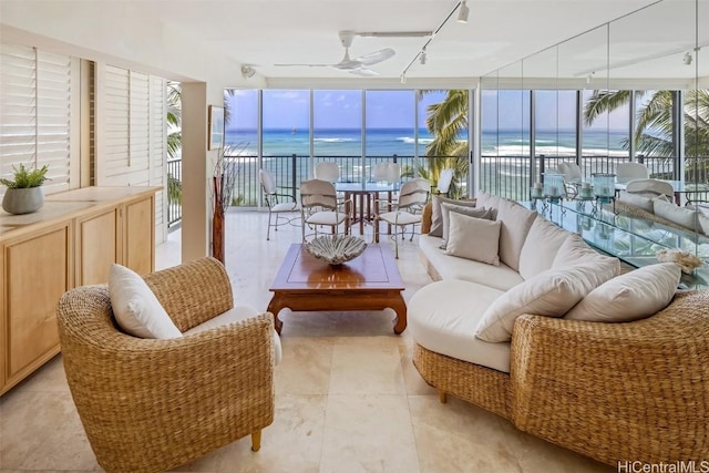 sunroom / solarium featuring ceiling fan, a water view, and track lighting