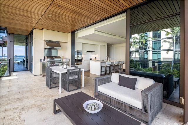 view of patio featuring an outdoor bar, exterior kitchen, grilling area, and an outdoor hangout area