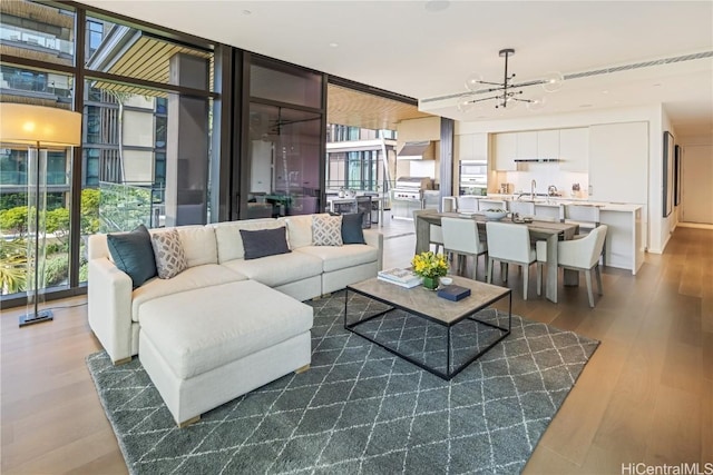 living room featuring expansive windows, an inviting chandelier, dark hardwood / wood-style flooring, and a wealth of natural light