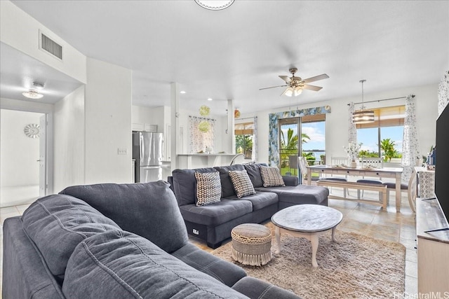 living area with a ceiling fan and visible vents