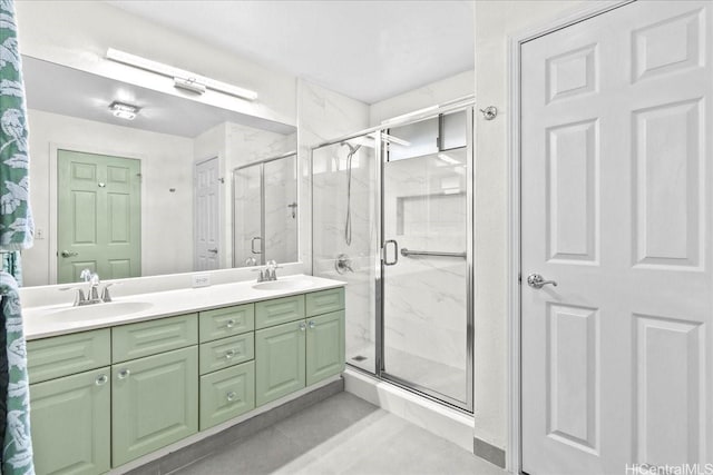 bathroom with double vanity, tile patterned floors, a stall shower, and a sink