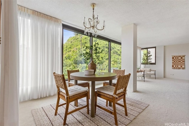 dining area with a textured ceiling, light colored carpet, a wealth of natural light, and a notable chandelier