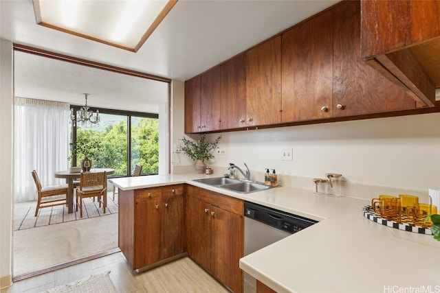 kitchen with dishwasher, brown cabinets, a peninsula, light countertops, and a sink