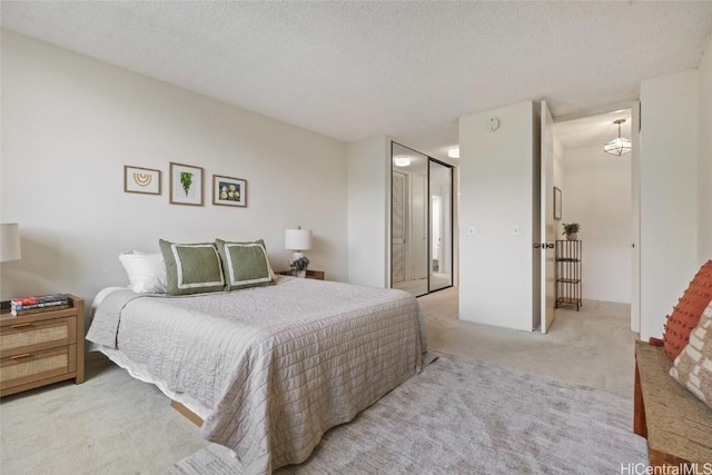 carpeted bedroom featuring a textured ceiling and a closet