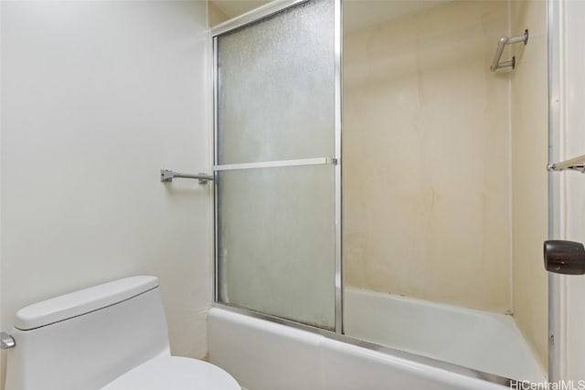 bathroom with combined bath / shower with glass door and toilet