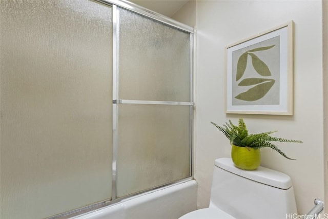 bathroom featuring enclosed tub / shower combo and toilet