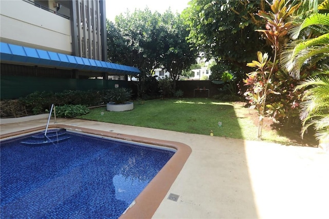 view of pool featuring a patio, a lawn, and fence