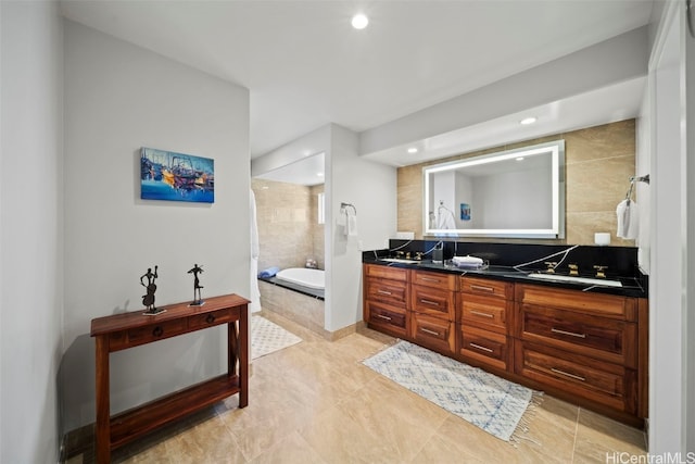 bathroom featuring a bath, recessed lighting, and double vanity