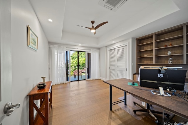 office with visible vents, ceiling fan, a tray ceiling, recessed lighting, and wood finished floors