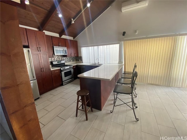 kitchen featuring a breakfast bar, backsplash, sink, a center island, and stainless steel appliances