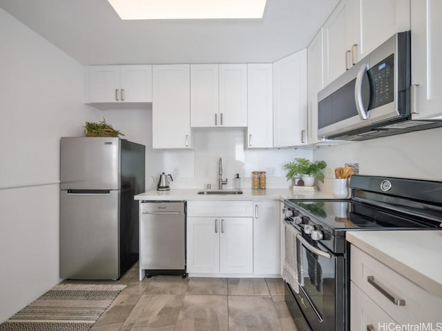 kitchen featuring sink, appliances with stainless steel finishes, and white cabinetry