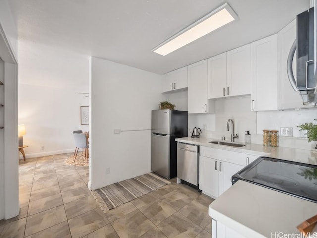kitchen featuring sink, appliances with stainless steel finishes, white cabinetry, and light tile patterned floors