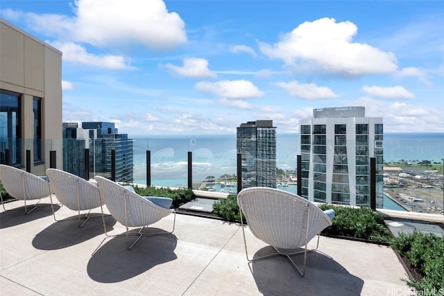 view of patio featuring a water view, a balcony, and a city view