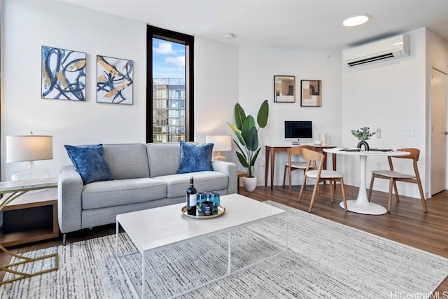 living area with a wall unit AC and wood finished floors