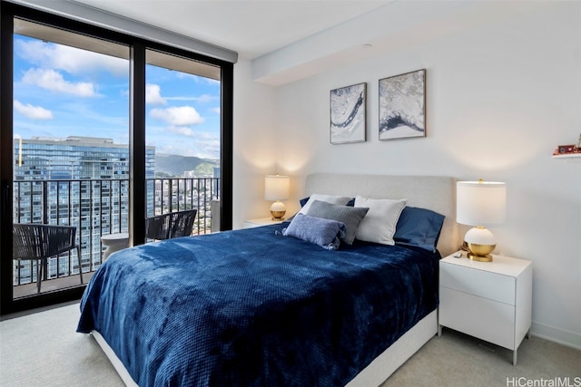 bedroom featuring access to exterior, expansive windows, baseboards, and carpet flooring