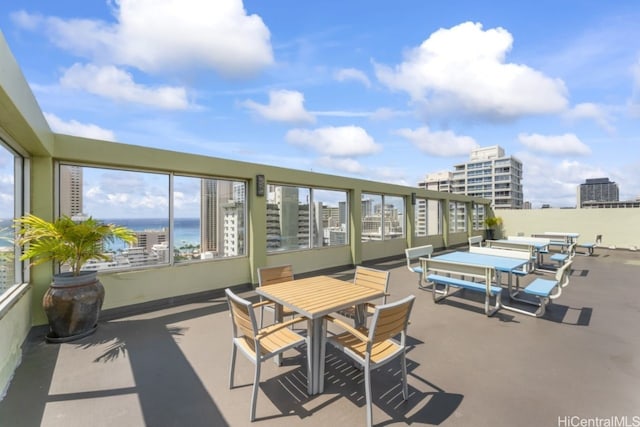 view of patio with outdoor dining area, a water view, and a city view