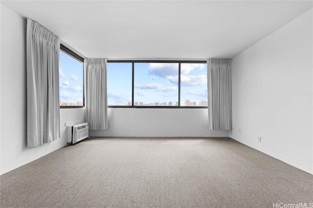 unfurnished room featuring carpet floors and a wall unit AC