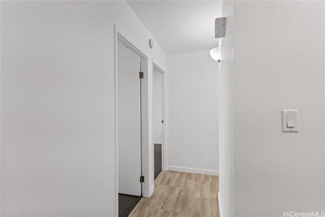 hall with light wood finished floors and baseboards