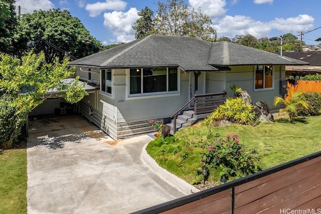 view of front of home with driveway, a front lawn, roof with shingles, and fence