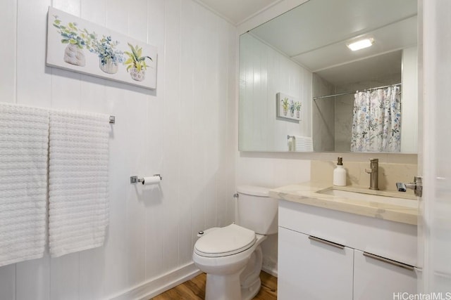 bathroom with curtained shower, vanity, toilet, and wood finished floors