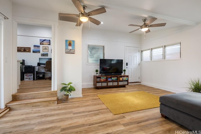 living room featuring light wood finished floors, baseboards, and a ceiling fan