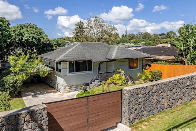 view of front of property with a shingled roof and fence