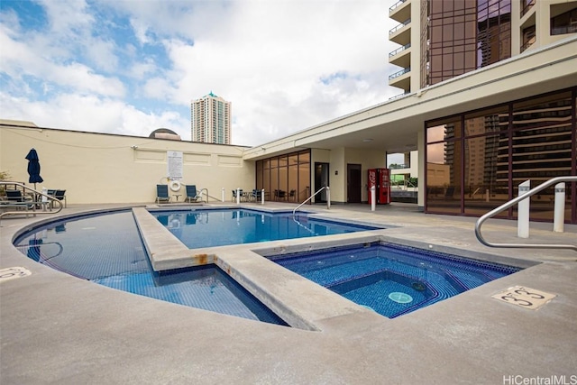 pool with a community hot tub and a patio