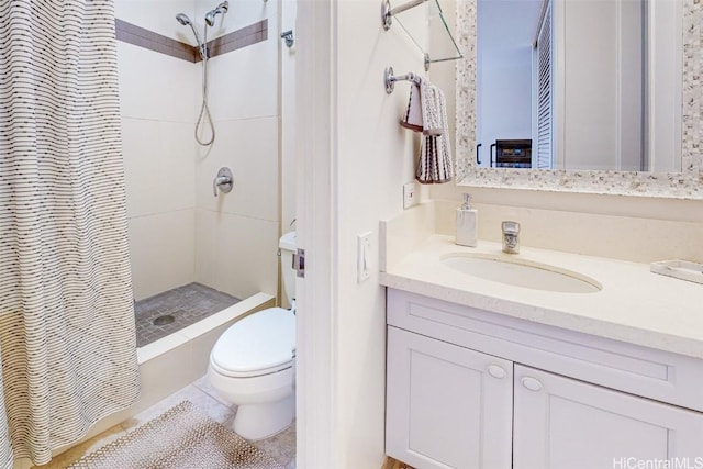 bathroom featuring tiled shower, vanity, and toilet