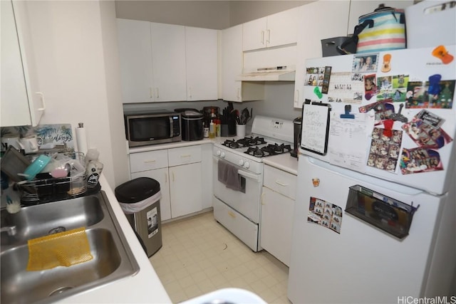 kitchen with light countertops, white appliances, a sink, and white cabinetry