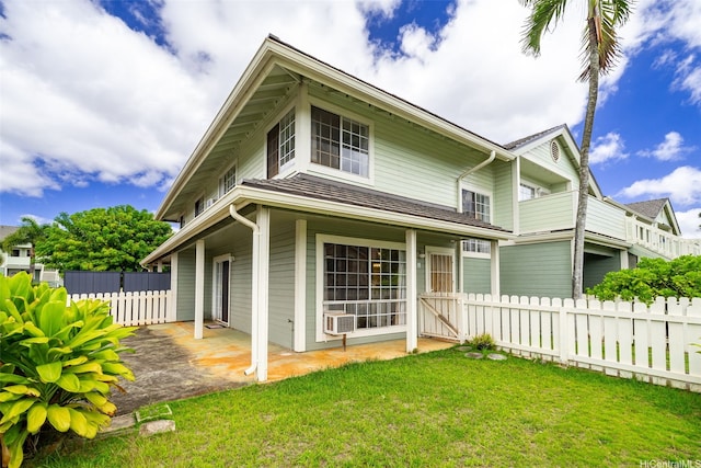 view of front of property with a patio area, a front lawn, and fence
