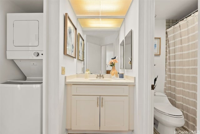 bathroom featuring toilet, vanity, and stacked washer and clothes dryer