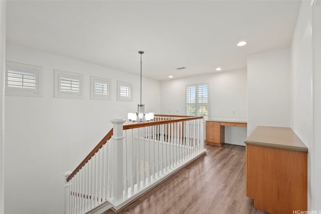 interior space featuring light wood finished floors, recessed lighting, a chandelier, an upstairs landing, and visible vents
