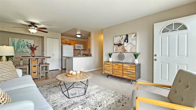 living room featuring ceiling fan, carpet, and sink