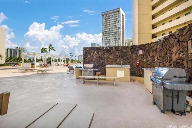 view of patio / terrace featuring a city view, an outdoor kitchen, and area for grilling